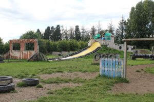 Wooden obstacles and tyres with a water slide forming a military style assault course