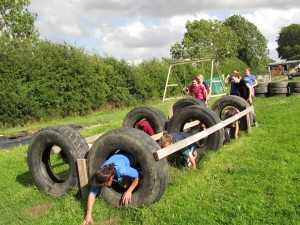 Hen Parties Kilkenny A group of girls on a hen party crawl through a tyre obstacle whilst others watch.