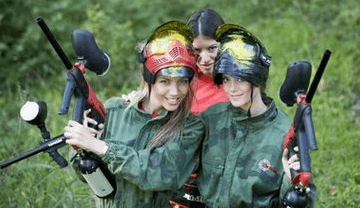 Three girls in camouflage gear pose with paintball guns and masks after a paintball game in Kilkenny arranged by Hen Parties Kilkenny.