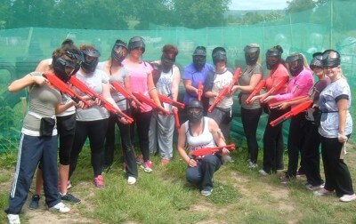A group of ladies holding splatball guns after taking part in a splatball hen party arranged by Hen Parties Kilkenny.